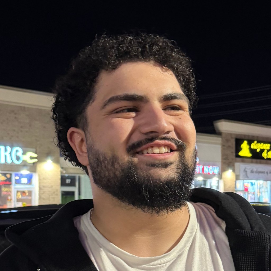 shaaf smiling, with a grid of colored squares over his photograph.